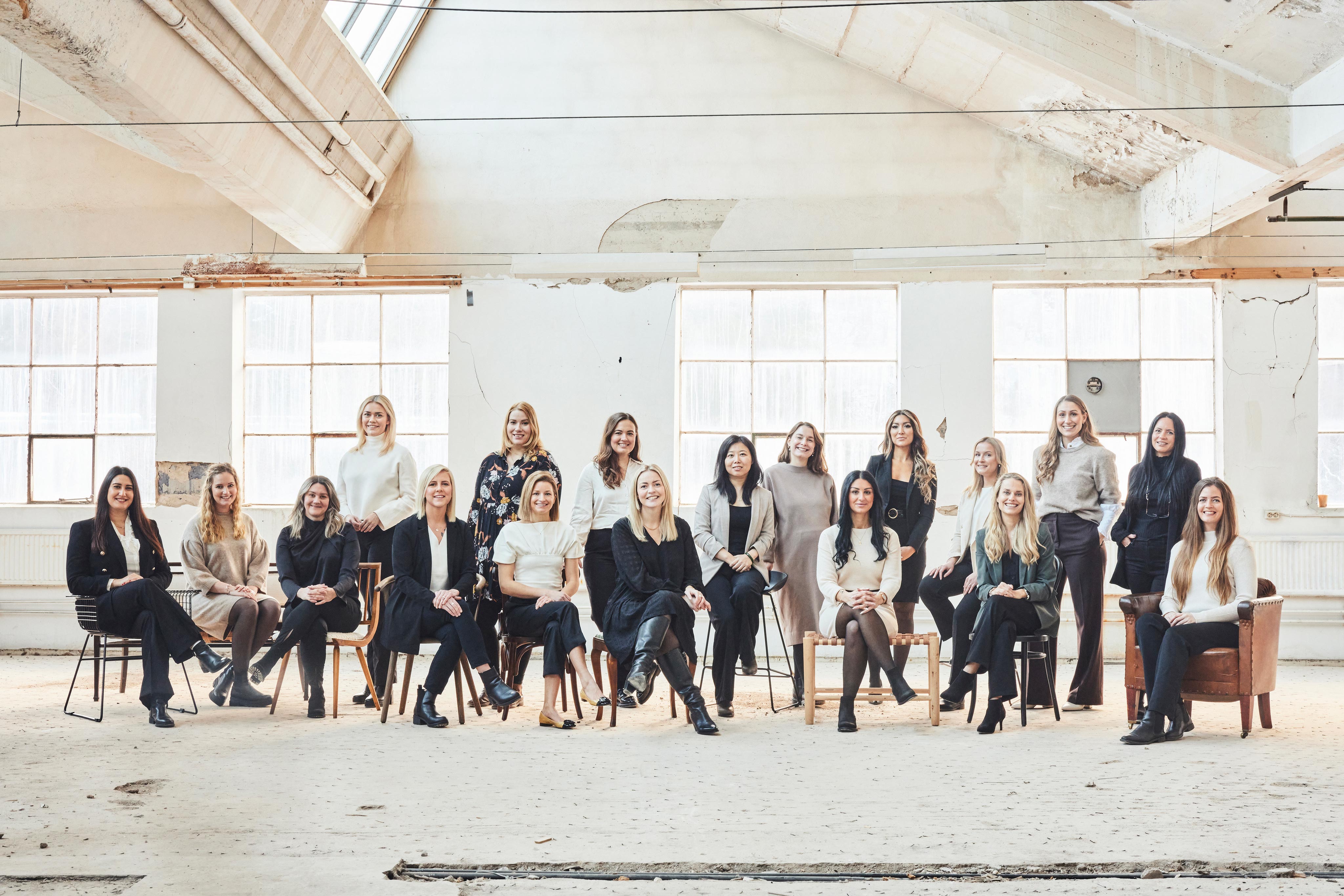 Ett gruppfoto på 18 av kvinnorna på listan Årets unga ledande kvinna 2022. Kvinnor na befinner sig i en gammal industrilokal.